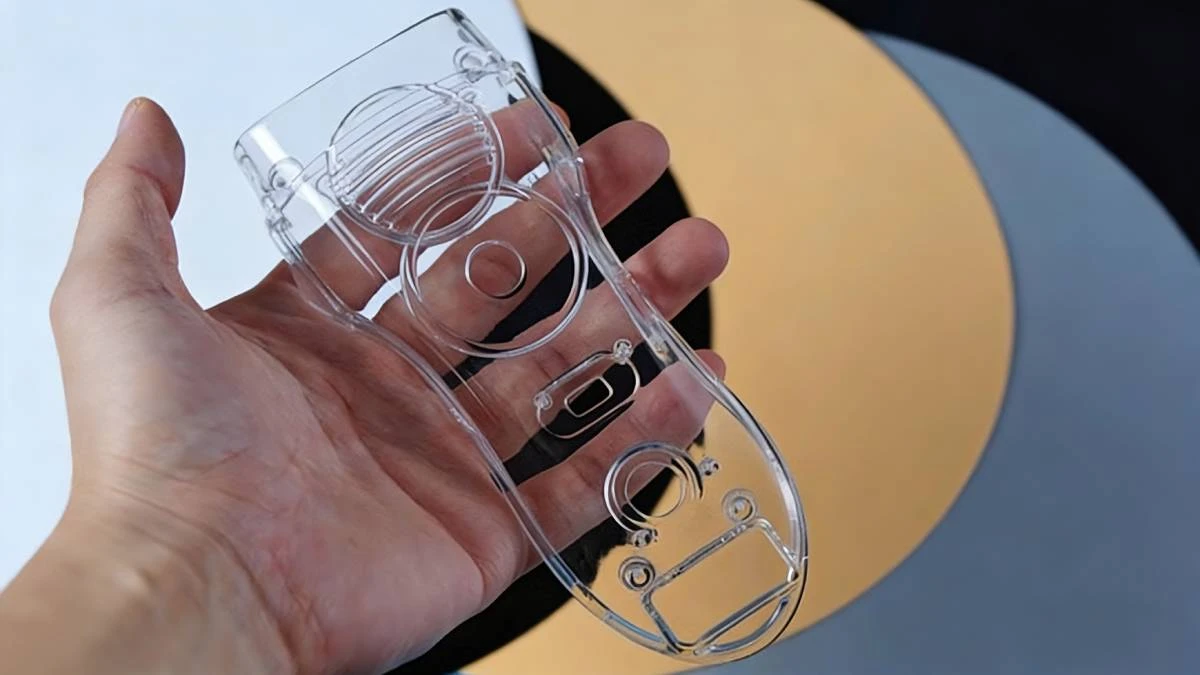 Handheld display of 3D printed transparent complex component made with NextShapes Precision Clear, highlighting intricate internal structures and excellent mechanical transparency