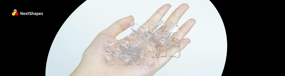 Close-up of a hand holding 3D printed petal samples created with NextShapes 8001 transparent resin, highlighting exceptional clarity, smooth finish, and bubble-free results.