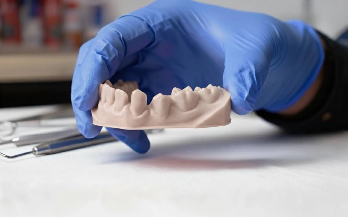 Clinical display of 3D printed mandibular dental model held in hand made with NextShapes Dental Model Resin, showcasing anatomical accuracy and clinical realism