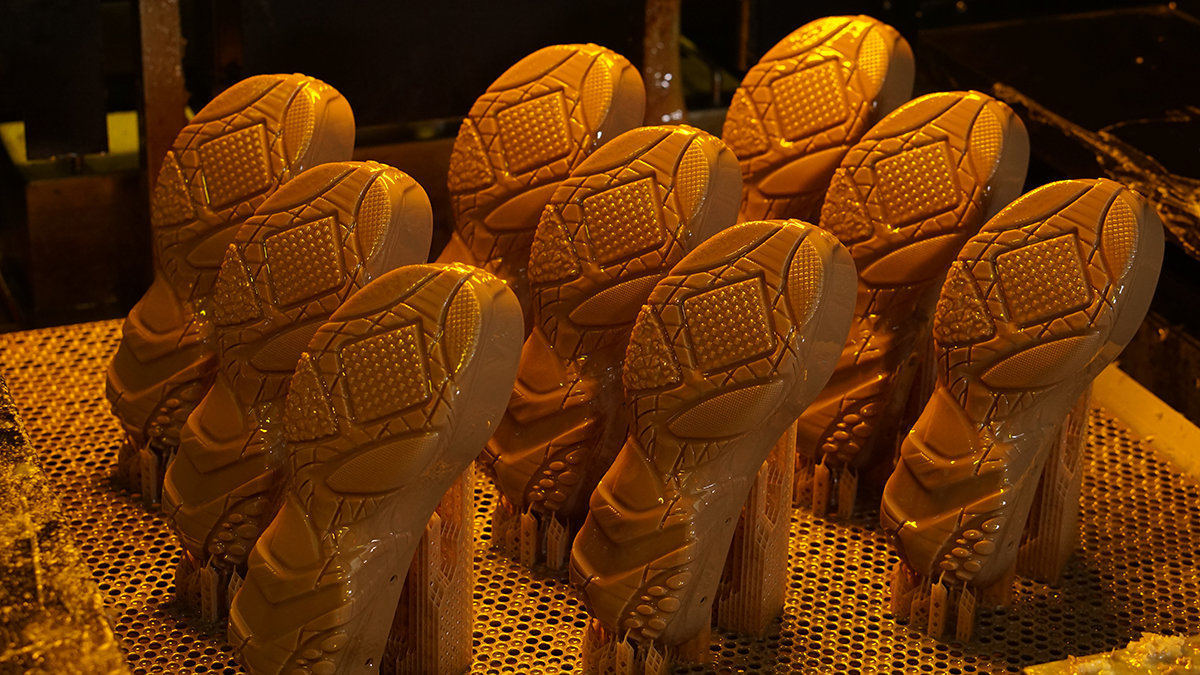 Batch of 3D printed shoe sole prototypes on an SLA printer build plate, made with NextShapes Precision Model resin